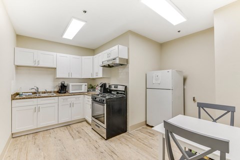 A kitchen with a black stove top oven and white cabinets.