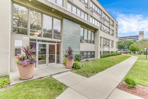 A building with a glass facade and a walkway in front. at Academy at Drexel Apartments, Illinois, 60637