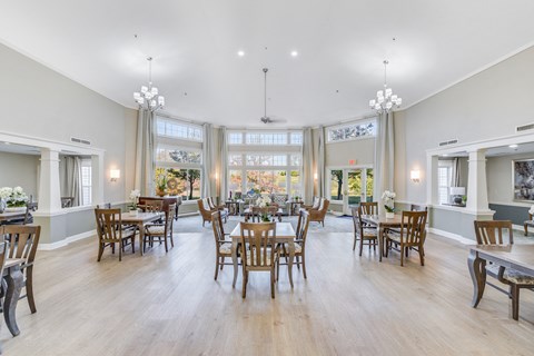 A large dining room with wooden chairs and tables.