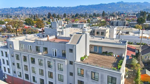 A large white building with a balcony overlooking a city. at Acton Courtyard, California
