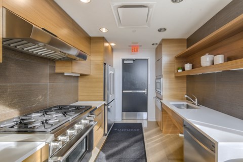 A modern kitchen with a stove top oven and a sink.