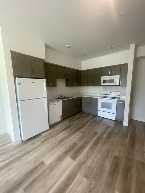 A kitchen with a white fridge and a white oven.