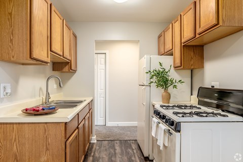 A kitchen with wooden cabinets and a white refrigerator.