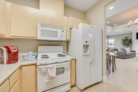 Kitchen with white appliances and wood cabinets at Sierra Creek Apartments, California