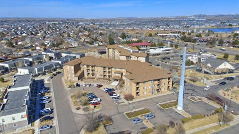 A large building with a parking lot in front of it.at Sable Ridge Senior Residences South, Denver Colorado