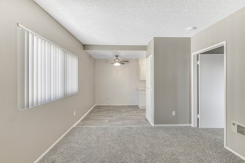 A spacious room with a ceiling fan and a door on the right side.
