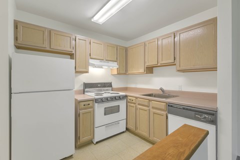 A kitchen with wooden cabinets and white appliances.