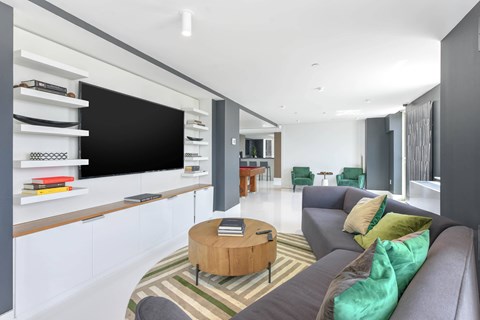 A modern living room with a grey couch and a wooden coffee table.