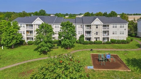 A large apartment complex with a playground in the front yard.