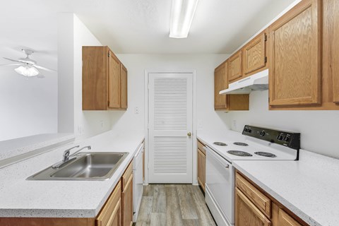 A kitchen with wooden cabinets and a white countertop.