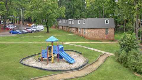 A playground with a blue slide and a green roof.