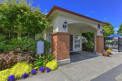 A house entrance with a sign and a potted plant.