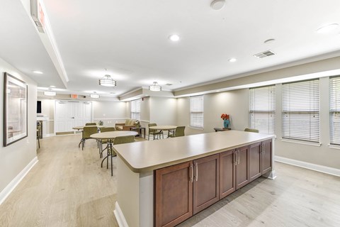 A spacious kitchen with a long counter and chairs.
