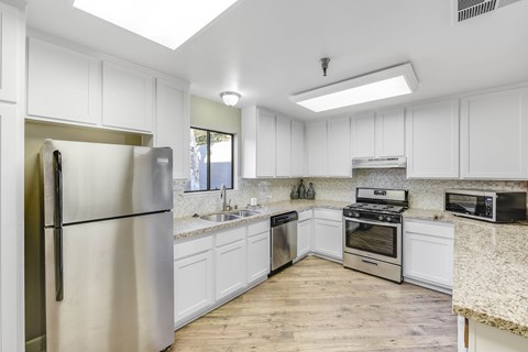 A kitchen with white cabinets and stainless steel appliances.