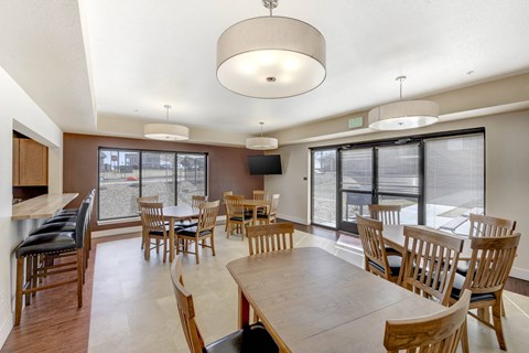 A large dining room with a long table and chairs.