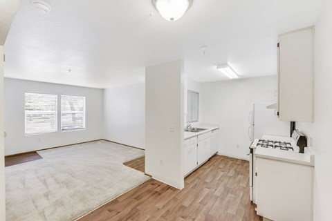 A kitchen with white cabinets and a white stove top oven.