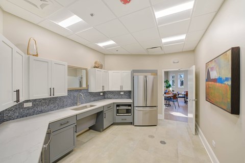 A kitchen with a refrigerator, sink, and oven.