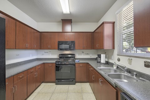 A kitchen with brown cabinets and a black stove top oven.