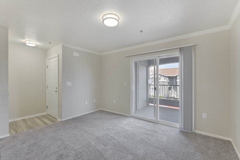 Empty apartment living room with balcony access at Corsair Park Senior Apartments, California