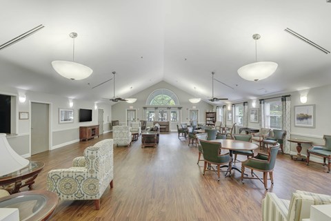 A spacious living room with a high ceiling and wooden floors.