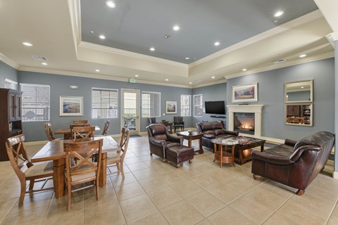 A spacious living room with a fireplace and a dining table.
