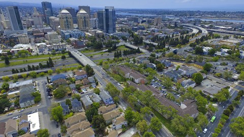 A cityscape with a mix of residential and commercial buildings at Oak Village Apartments, Oakland, CA