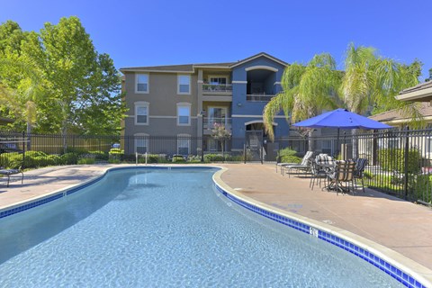 Swimming pool with patio furniture and iron safety fence at Whitney Ranch Apartments, Rocklin, 95765