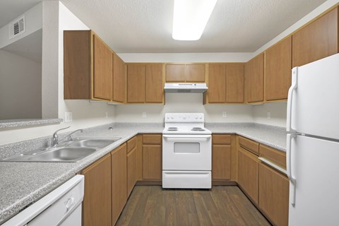 A kitchen with wooden cabinets and a white refrigerator.