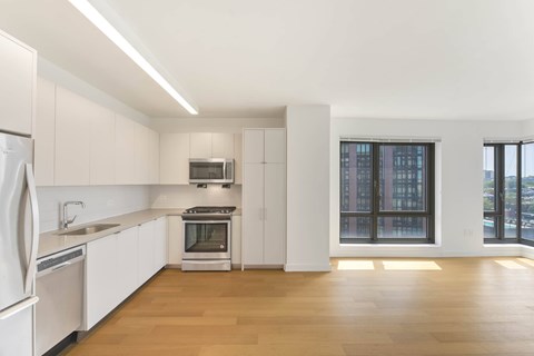 A kitchen with white cabinets and a stainless steel refrigerator.