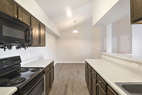 A kitchen with black appliances and wooden cabinets.