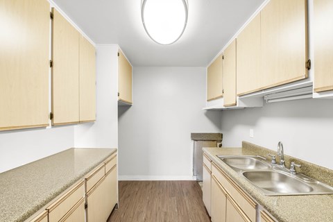 A kitchen with wooden cabinets and a sink.