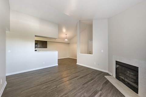 A living room with a fireplace and wood flooring.
