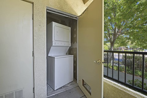 A white refrigerator and freezer are installed in a small outdoor space at Hurley Creek Apartment Homes, Sacramento, California