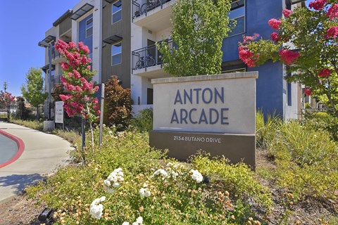 Property entrance sign with colorful landscaping at Anton Arcade Apartments, Sacramento, CA 95825