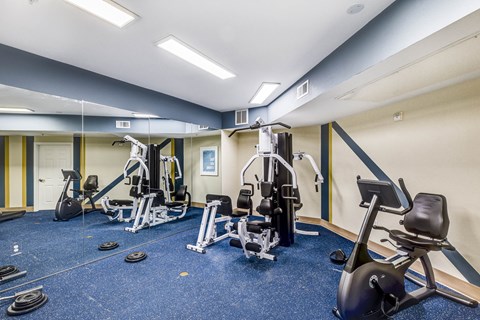 A gym with a variety of equipment including treadmills, weights, and exercise machines.at Sable Ridge Senior Residences South, Denver