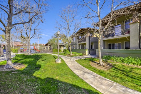 A sunny day at a residential area with apartment buildings and a playground at Yorba Linda Apartments, Yorba Linda, CA