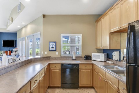 A kitchen with wooden cabinets and a black refrigerator.