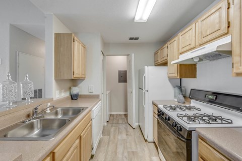 A kitchen with a white refrigerator and stove.