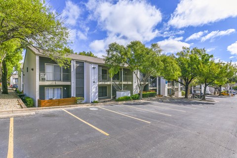 A parking lot in front of a building with trees. at Canvas, Austin, Texas