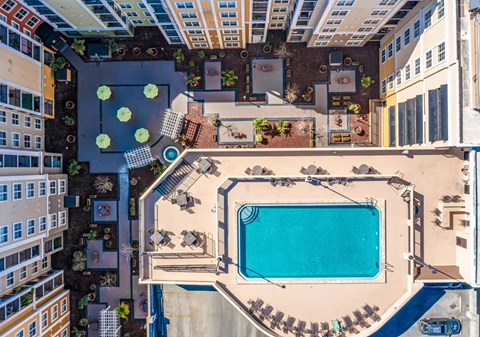 An aerial view of a pool surrounded by buildings.