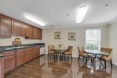 A kitchen with brown cabinets and a dining table with chairs.