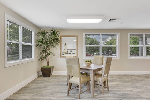A dining room with a table and chairs.