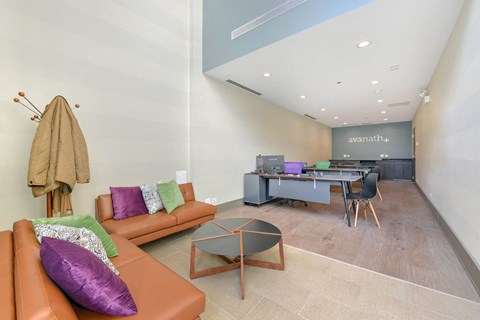 A living room with a brown couch and a glass coffee table.