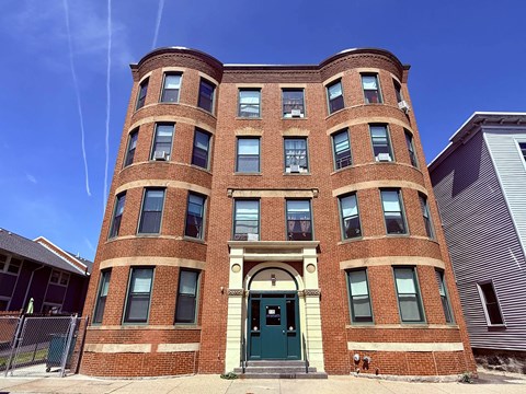 Historic brick facade with rounded window towers at Logo Apartments, Roxbury, 02119