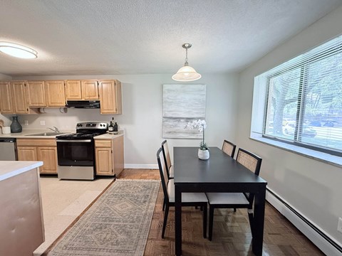 A kitchen with a dining table and chairs.