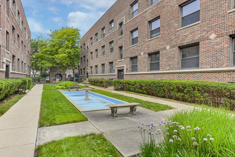 A brick building with a pool in the courtyard.