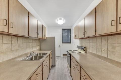 A kitchen with wooden cabinets and a tiled backsplash.