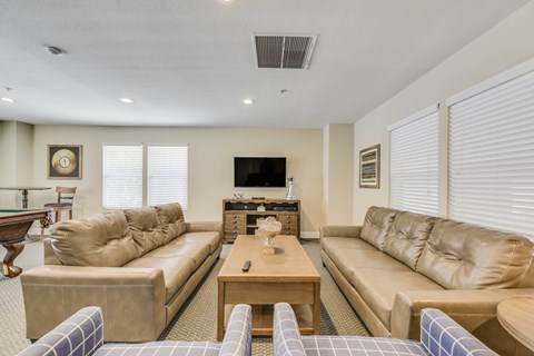 A living room with a pool table and a television.
