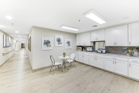A kitchen with white cabinets and a dining table with chairs.