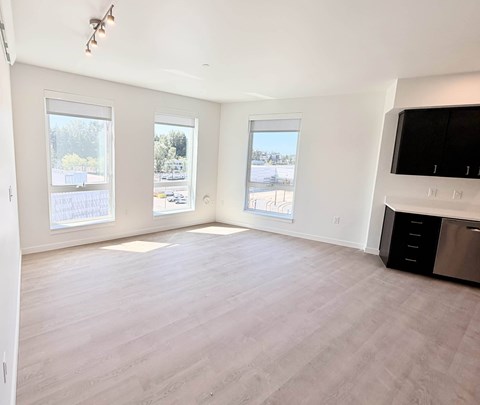 A spacious room with a large window overlooking a parking lot.